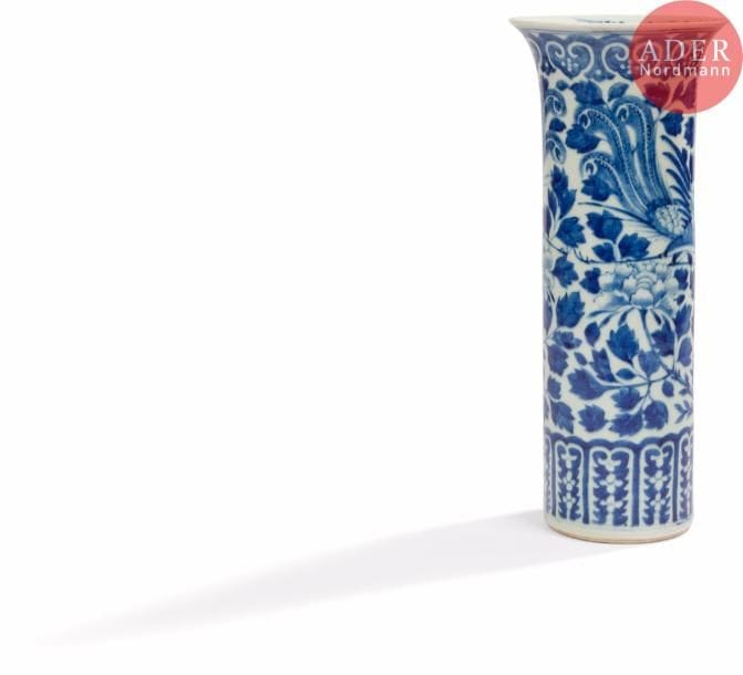 CHINE - XIXe siècle
Vase rouleau en porcelaine bleu blanc à décor de phoenix nichés sur des branches de lotus épanouis dans leur feuillage, orné d’une frise de lingxi en bordure de col. (Nombreuses fêlures sous le talon).
H. : 34,5 cm.