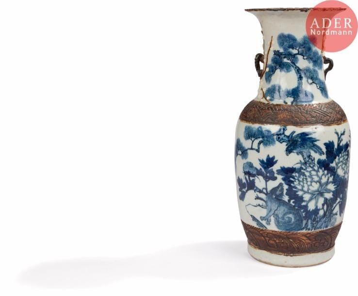 CHINE, Nankin - XIXe siècle
Vase en porcelaine émaillée beige craquelée à décor en bleu sous couverte d’un loup sous un pin sur lequel est perché un rapace. (Restauration en bordure de col).
H. : 45,7 cm. 