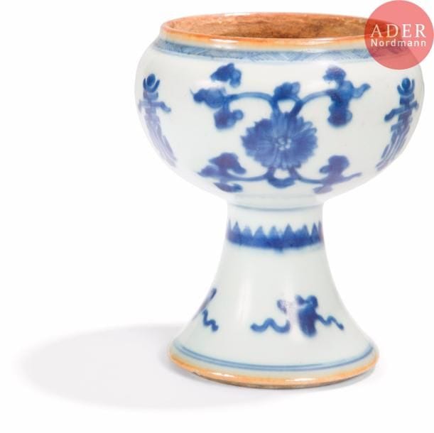 CHINE - Époque KANGXI (1662 - 1722)
Bol sur piédouche en porcelaine décoré en bleu sous couverte de fleurs de lotus stylisées et caractères shou alternés. 
H. : 13 cm