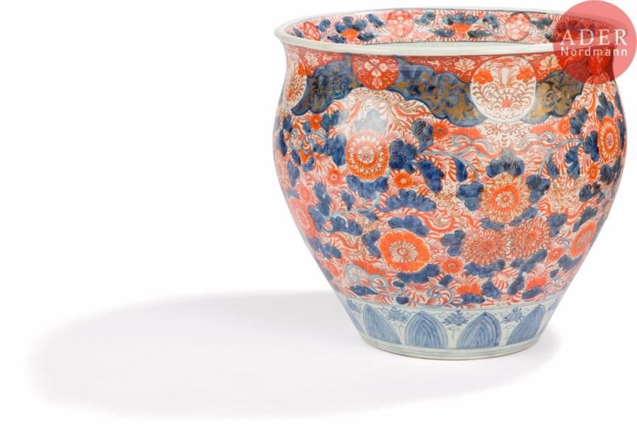 JAPON - Epoque MEIJI (1868 - 1912)
Vasque en porcelaine à décor émaillé polychrome dit « imari » en rouge de fer, bleu et or de fleurs dans des rinceaux feuillagés et médaillons de fleuron.
H. : 40 cm. Diam. : 37 cm.