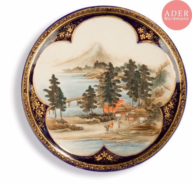 JAPON, Fours de Satsuma
Époque MEIJI (1868 - 1912)
Petite assiette en faïence de Satsuma émaillée polychrome d’une scène de paysans marchant au bord de l’eau, le Mont Fuji au loin. Signée Unzando. 
Diam. : 15,8 cm.