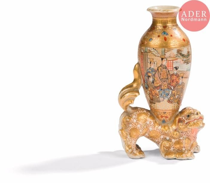 JAPON, Fours de Satsuma
Époque MEIJI (1868 - 1912)
Groupe en faïence de Satsuma émaillée polychrome et or, chimère marchant surmontée d’un vase à décor de scènes représentant des seigneurs et femmes au bord de l’eau. (Petit égrenure en bordure).
H. : 11,7 cm.