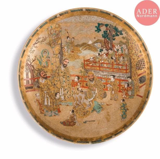 JAPON, Fours de Satsuma
Époque MEIJI (1868 - 1912)
Plat rond en faïence de Satsuma émaillée polychrome et or d’enfants, lettrés dans la cours d’un pavillon, des immortels dans les nuages en arrière-plan avec le Mont Fuji. (Fêlure en bordure d’environ 13 cm).
Diam. : 31,1 cm.