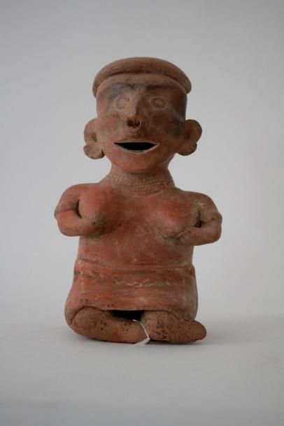 Femme assise vêtue d'une jupe, Ses mains soutiennent ses seins et symbolisent la fécondité. Elle est parée de bracelets, d'une nariguera, de boucles d'oreilles et d'une coiffe. Terre cuite beige à engobe rouge et décoration beiges. Traces d'oxydes de manganèse. Culture Nayarit, Mexique, 100 av.-250 apr.-JC.  H. 26 - l. 15 - Ep. 14 cm Provenance: Collection privée Allemagne. Bibliographie: Reproduit dans l'ouvrage "Frauen des Alten Amerika", ed Verlag Arte Amerika, Stuggart, 2002, p.187, fig 279. Un test de thermoluminescence sera remis à l'acquéreur. Vente Thion Enchères,  Evreux du 12/02/2012, lot. 140.