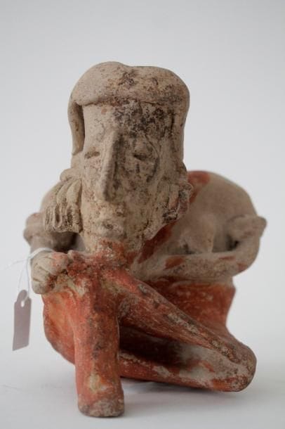 Femme assise, le menton posé son genou droit. Elle est vêtue d'une jupe et parée de bracelet et de boucles d'oreilles à pendeloques. Terre cuite beige à engobe rouge avec importantes traces  d'oxyde de manganèse. Culture Jalisco, Mexique, 100 av.-250 apr. J.-C. H. 15.5 - l. 1 - Ep. 12 cm. Provenance: Collection Ulrich Hoffmann, Allemagne. Bibliographie: Reproduit dans "Fascinazion",ed Verlag Arte Amerika, Stuggart, 2002, p.70. Un test de thermoluminescence sera remis à l'acquéreur. Vente Thion Enchères du 12/02/2012, lot. 141.