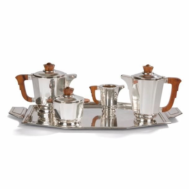 Charles JULIEN (XIXe-XXe) Orfèvre 
Service à thé et café en métal argenté de 5 pièces composé d’une cafetière, d’une théière, d’un sucrier, d’un pot à lait et d’un grand plateau. Pièces à corps octogonal, prises en palissandre. Chaque pièce porte le poinçon de maître orfèvre sous la base. 