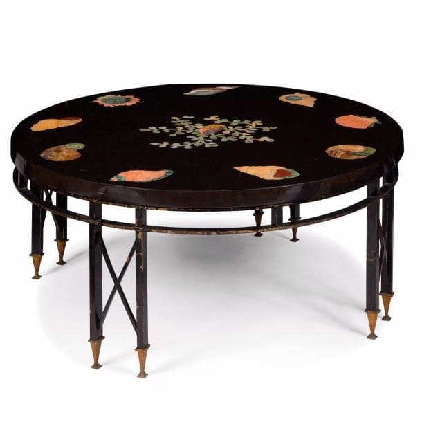 TRAVAIL NÉOCLASSIQUE des ANNÉES 1940/50
Coquillages et coraux
Rare table basse circulaire. Base en laiton, en partie laqué noir, constituée de quatre doubles jambages, aux entretoises en x et reposant sur des pieds en gaine terminés par des patins carrés, réunis par une double ceinture circulaire. Plateau au riche et précieux décor réalisé en marqueterie de marbre et de pierres dures. Restaurations et altérations à la laque du piètement, plateau accidenté. H. 43 cm - D. 92 cm
ILLUSTRATION DU LOT NON CONTRACTUELLE