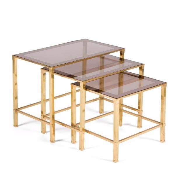 ANNÉES 1960
Suite de trois tables gigognes en tube de laiton carré. Dessus en verre fumé et au tain miroir.  47 x 60 x 35 cm - 42 x 50 x 35 cm - 37 x 40 x 35 cm