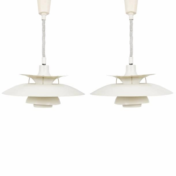 Poul HENNINGSEN (1894-1967) Designer & Louis POULSEN Éditeur
Charlottenborg PH 5, modèle créé en [1926]. 
Paire de suspensions, chacune composée de disques incurvés concentriques et de dimensions diverses, en métal laqué blanc, bleu et rouge à l’intérieur. Usures et torsions de certaines coupes en métal. D. 50 cm