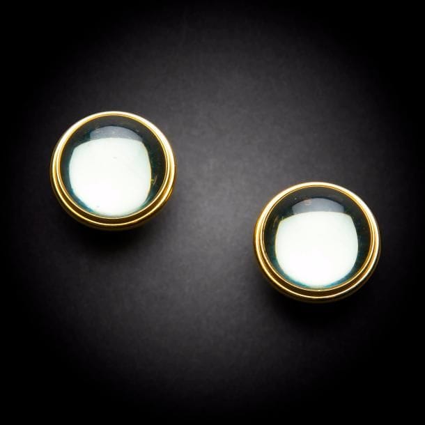 Maison LALIQUE d’après un modèle de Marie-Claude LALIQUE (1935-2003)
Cabochon 
Paire de clips d’oreille en cristal gris et métal doré. Chaque clip signé LALIQUE France au revers de la platine. D. 2,5 cm