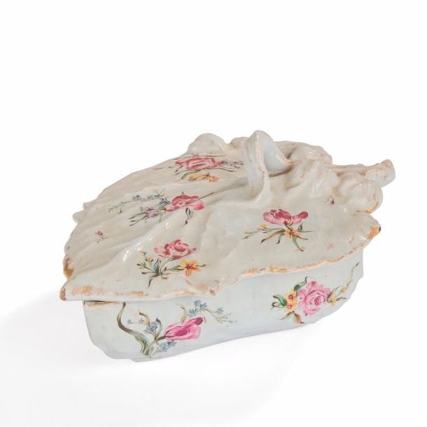 Émile GALLÉ (1846-1904)
Roses, thunbergias, hémérocalles et tulipes
Bonbonnière figurant une feuille. Épreuve en faïence à décor de semis floraux émaillés polychromes sur fond blanc. Bords frottés à l’or. Usures à l’or et petites sautes d’émail sur le pourtour du couvercle. Signée E. GALLÉ Nancy Déposé sous la base. L. 24 cm 