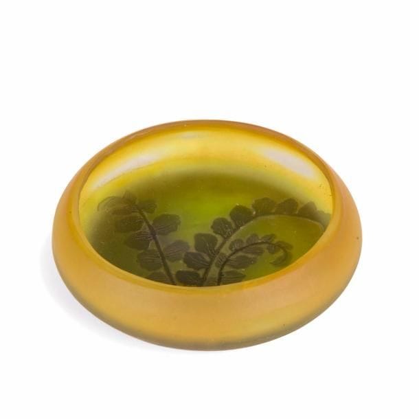 Établissements GALLÉ (1904-1936)
Fougère
Baguier ou petit vide-poche circulaire. Épreuve en verre multicouche au décor, dégagé à l’acide, traité violet sur fond jaune. Signé GALLÉ à l’étoile gravé en camée à l’acide. D. 9,5 cm