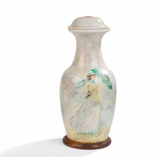 TRAVAIL MODERNE d’après Claude MONET (1840-1926) 
Femme à l’ombrelle tournée vers la droite 
Pied de lampe. Épreuve en céramique peinte polychrome. Base circulaire en bois. Signé SIMONELOU vers la base. H. totale 57 cm 