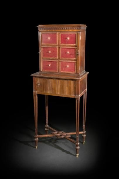 Cartonnier en acajou mouluré, les pieds ajourés en gaine réunis par une entretoise, ouvrant à un rideau ; la partie supérieure à six cartons de maroquin rouge doré aux petits fers.
Dans le goût de Charles-Guillaume Diehl (1811-1885).
XIXe siècle (accidents et manques).
H : 154 cm, L : 60 cm, P : 39 cm