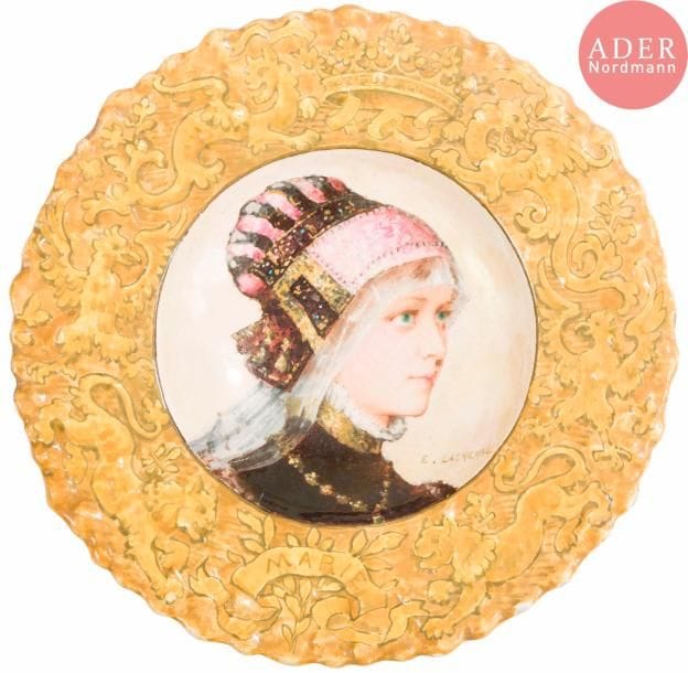 Edmond LACHENAL (1855-1948)Marie, 1885Plat creux à pourtour chantourné. Épreuve en céramique émaillée polychrome, le portrait au centre, le marli au décor héraldique. Circa 1885. Petites usures au pourtour. Signé dans le décor et contresigné et daté au dos. D. 34 cm