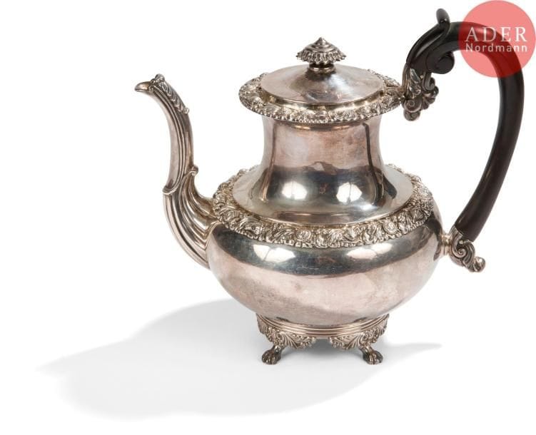Belle théière en argent reposant sur quatre pieds griffe, la partie médiane du corps ciselée de coquillages en reprise sur le haut du col. Chiffrée sur le corps de lettres entrelacées.
PARIS 1819 - 1838
Orfèvre : ODIOT, poinçon d’orfèvre et en toutes lettres
Poids brut : 960,70 g - H : 21 cm