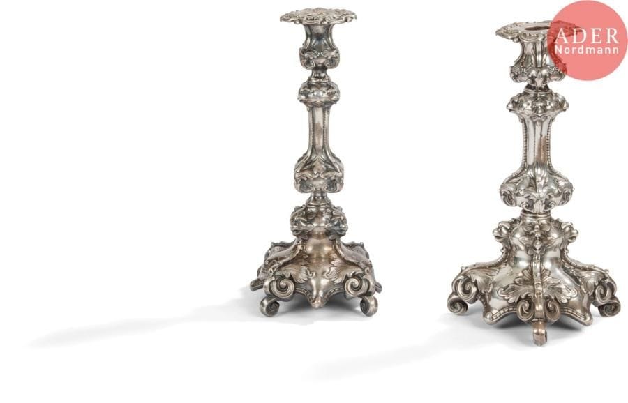 Amusante paire de flambeaux et leurs bobèches en métal estampé, la base de forme carrée est à enroulements, au départ du fût à pans figurent aux quatre angles des têtes de rapace en rappel sur le haut du fût au départ de la bobèche.
Travail étranger
Orfèvre : M&Cie
Poids : 742,50 g - hauteur : 30,8 cm