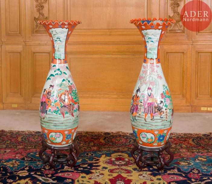 JAPON, Fours de Kutani - Epoque MEIJI 
(1868 - 1912)
Grande paire de vases à col évasé et chantourné en porcelaine décorée en émaux polychromes d’acteurs et jeunes femmes parmi les pivoines. 
H : 105 cm