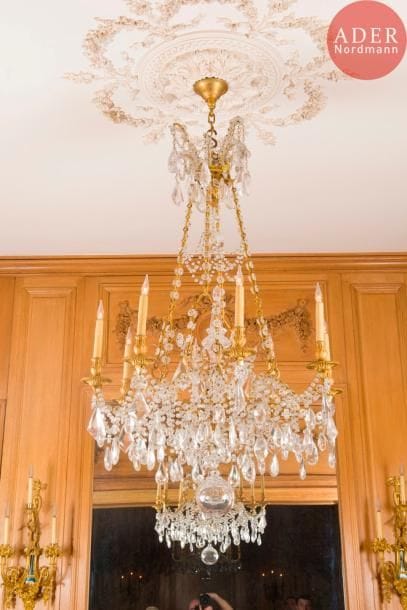 Lustre en bronze doré et verre taillé à huit lumières et décor de pampilles.
Style néoclassique (manque une guirlande).
H : 135 cm, L : 80 cm