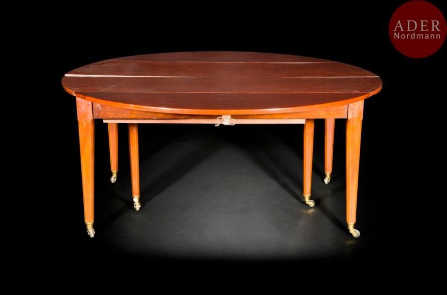 Table circulaire en acajou, reposant sur six pieds en gaine à angles abattus terminés par des roulettes ; (le mécanisme doublé en capacité avec ajout de pieds supplémentaires rabattables à une époque postérieure).
Époque Louis XVI (transformation au mécanisme)
(avec deux allonges en acajou).
H : 71 cm, D : 158 cm
