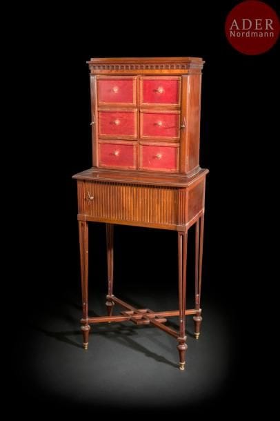 Cartonnier en acajou mouluré, les pieds ajourés en gaine réunis par une entretoise, ouvrant à un rideau ; la partie supérieure à six cartons de maroquin rouge doré aux petits fers.
Dans le goût de Charles-Guillaume Diehl (1811-1885).
XIXe siècle (accidents et manques).
H : 154 cm, L : 60 cm, P : 39 cm