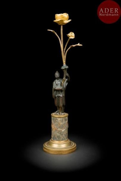 Grand flambeau au chinois en bronze patiné et doré, le bras de lumière sortant d’une corne d’abondance, reposant sur un socle en marbre brèche et une base circulaire de bronze doré.
Début du XIXe siècle
H : 41 cm