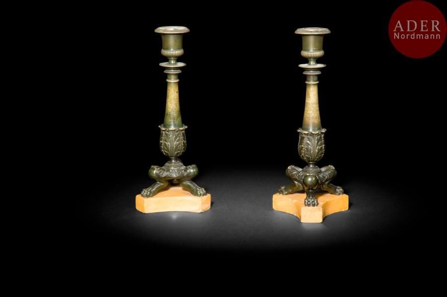 Paire de flambeaux en bronze patiné, à fût en balustre et pieds en jarret, à décor de feuillages et godrons, la base en marbre jaune de Sienne.
XIXe siècle (usures)
H : 24 cm