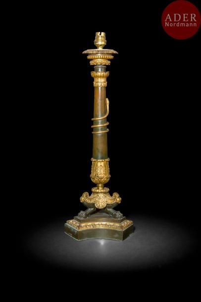 Grand flambeau en bronze patiné et bronze doré, la base triangulaire soutenant un piétement en jarret et un fût à serpent enroulé ; (monté à l’électricité).
Époque Louis-Philippe
H : 47 cm