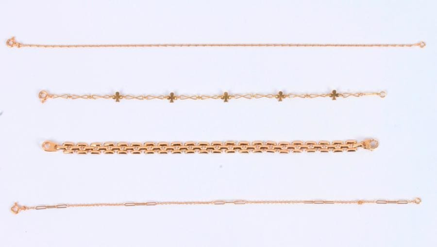 Suite de 4 bracelets en or 18K (750 ‰) dont trois en fines chaînettes, le dernier articulé de maillons géométriques imbriqués. 
Poids : 11,7 g