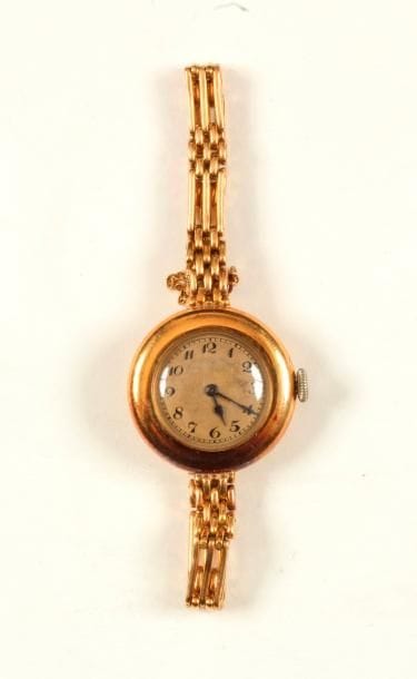 Montre de dame en or 18K (750 ‰), cadran rond, bracelet en or 18K articulé de longs maillons imbriqués, mouvement mécanique. Longueur : 17 cm environ. 
Poids brut : 27,2 g