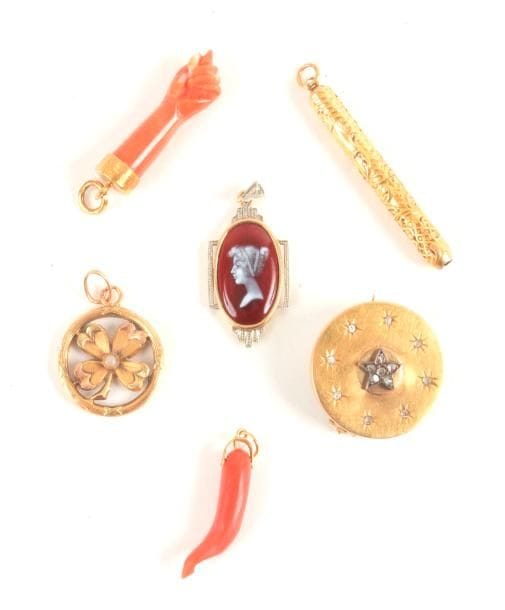 Lot de pendentifs en or 18K (750 ‰) : le 1er orné d'un trèfle; les deux suivants ornés d'un corail; le 4e émaillé; le 5e retenant un cure-dents. On joint une broche en or 18K ornée de diamants taillés en roses. 
Poids brut : 16,5 g