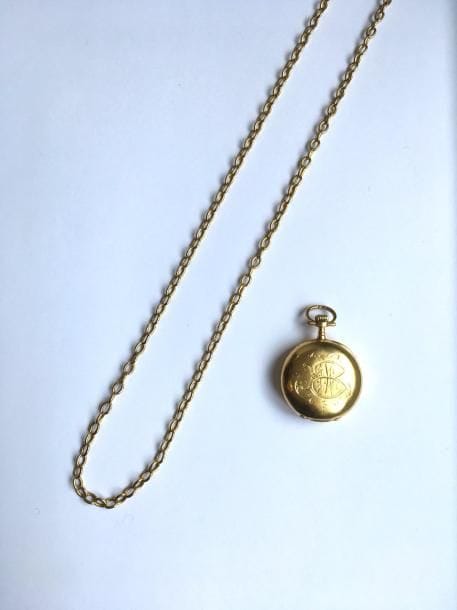 Montre de col en or 18K (750 ‰) coulissant sur une chaîne en or 18K, maillons ovales. 
Poids brut : 40,9 g
