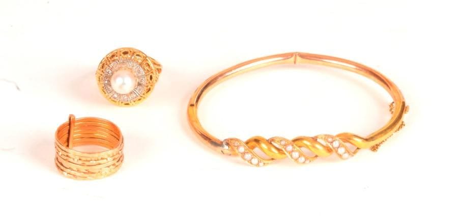 Lot de 3 bijoux en or 18K (750 ‰) (12,5 g) ET ARGENT (36 g) comprenant : un bracelet orné d'une torsade agrémentée de demi-perles, une bague semainier et une bague dôme, ajourée, ornée d'une perle de culture dans un entourage de diamants de taille 8/8.
Poids brut : 20,2 g