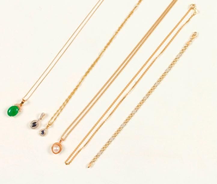 Suite de 4 pendentifs coulissant chacun sur une chaîne en or 18K (750 ‰) : les deux premiers en or 18K sertis d'un saphir dans un entourage de diamants; le 3e en or 18K serti d'un jade cabochon; le 4e en or 14K serti d'une perle de culture. On joint un bracelet en or 18K. Poids brut : 26 g