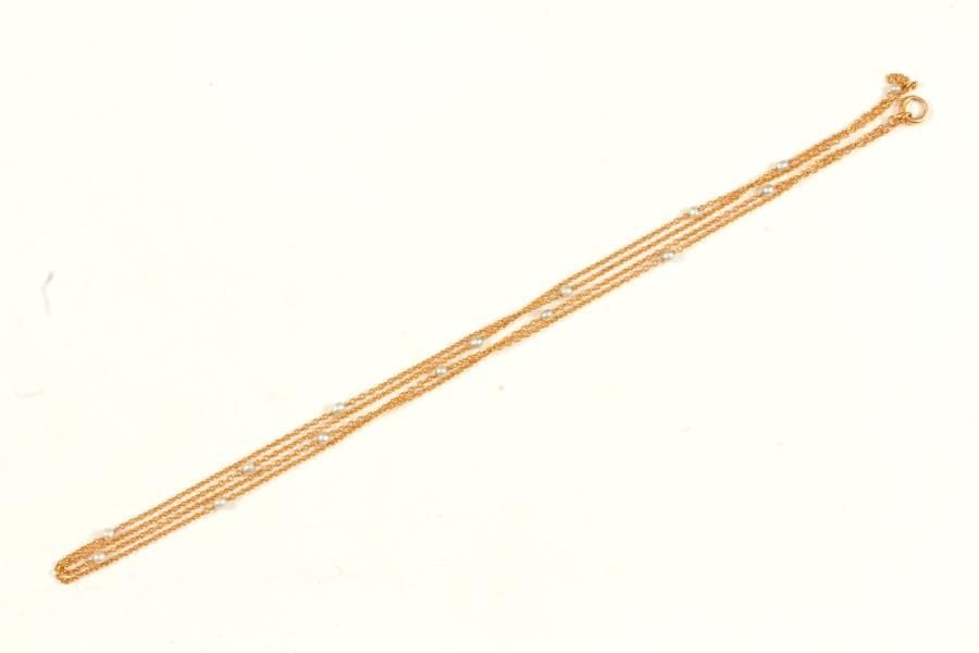 Chaîne de montre en or 18K (750 ‰), maillons jaseron, scandée de perles baroques (non testées). Longueur : 160 cm environ. 
Poids brut : 32,8 g