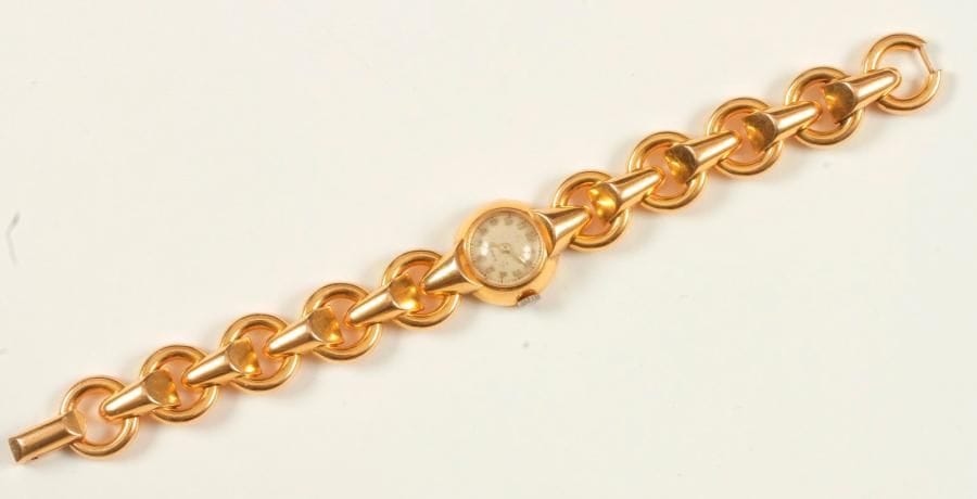 Montre de dame en or 18K (750 ‰), cadran circulaire, bracelet en or 18K articulé d'anneaux et barrettes asymétriques. Travail français des années 1940. Longueur : 18,2 cm environ. 
Poids brut : 38,2 g (remontoir métal)