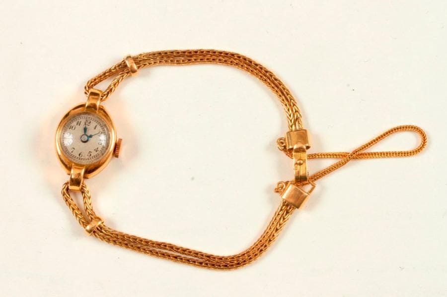 Fine montre de dame en or 18K (750 ‰), cadran rond, bracelet à deux brins en or 18K, mouvement mécanique. 
Poids brut : 11,8 g (accidents, mouvement à réviser, piqûres)