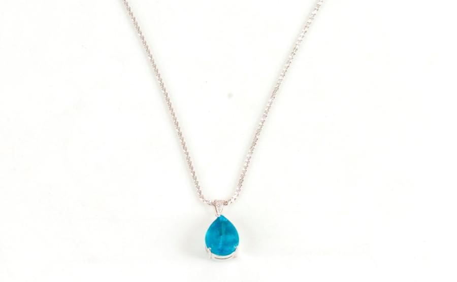 Pendentif en or gris 18K (750 ‰), orné d'une pâte de verre bleue, coulissant sur une chaîne en or gris. 
Poids brut : 12,5 g