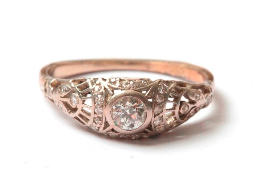 Bague en platine et en or gris 18K (750 ‰), ornée d'un diamant de taille ancienne, l'épaulement ajouré serti de roses. Tour de doigt : 50. 
Poids brut : 2,3 g (accidents)