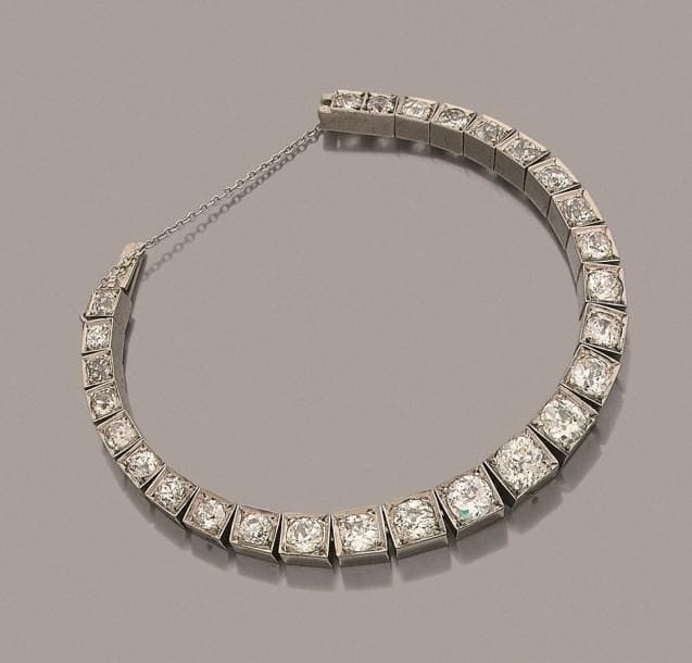 Bracelet en or gris 18K (750 ‰), articulé de 27 diamants ronds de taille ancienne. Travail français des années 1920. Longueur : 17,5 cm environ. 
Poids brut : 25,1 g