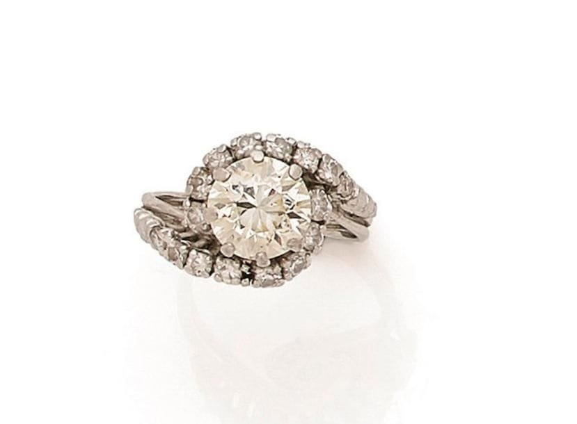 Bague tourbillon en or gris 18K (750 ‰), ornée d’un diamant demi-taille, l’entourage serti de diamants. Tour de doigt : 48. 
Poids brut : 5,8 g