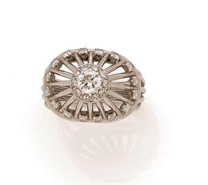 Bague « chapiteau » en fils d’or gris 18K (750 ‰), ornée d’un diamant de taille brillant dans un double entourage de diamants. Travail français des années 1950. Tour de doigt : 56/57. 
Poids brut : 8,7 g