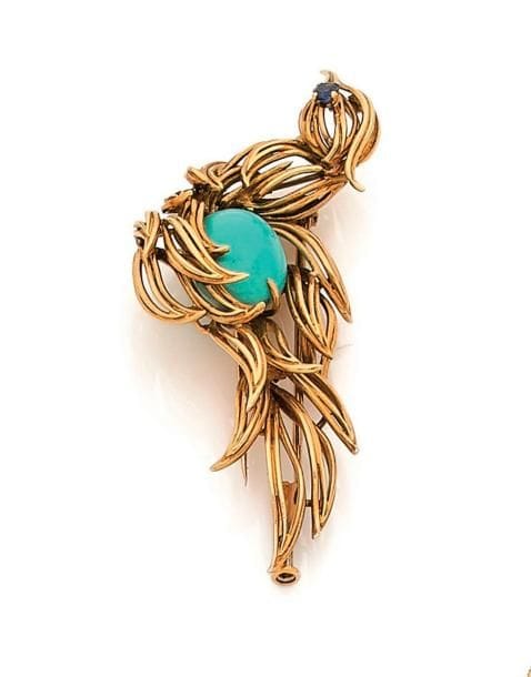 MELLERIO. Broche-clip en fils d’or 18K (750 ‰) représentant un oiseau, le corps serti d’une turquoise cabochon, l’œil souligné d’un saphir. Signé et numéroté. Dans son écrin. Hauteur : 6 cm environ. 
Poids brut : 13,1 g