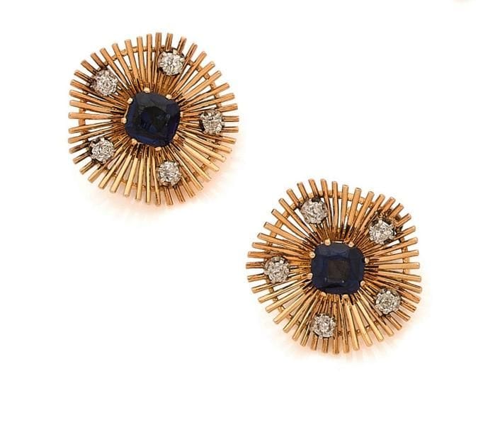 Paire de clips d’oreilles en fils d’or jaune 18K (750 ‰), chacun centré d’un saphir synthétique de forme coussin, piqué de diamants de taille ancienne. 
Poids brut : 17,1 g