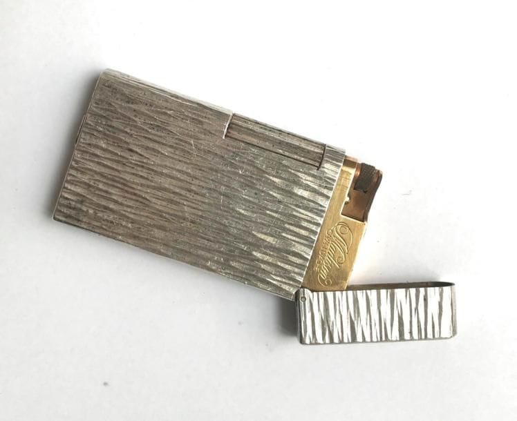 CARAN D’ACHE. Briquet en métal argenté guilloché. Signé.