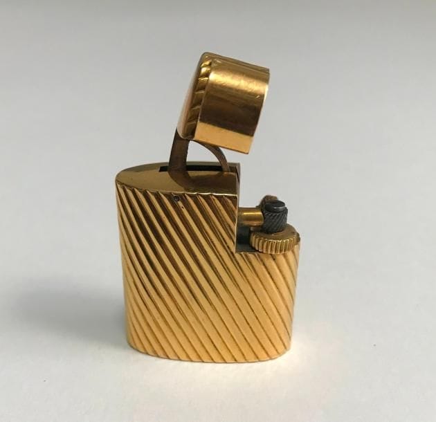 CARTIER. Briquet en or 18K (750 ‰) godronné signé et numéroté.
Poids brut : 49 g