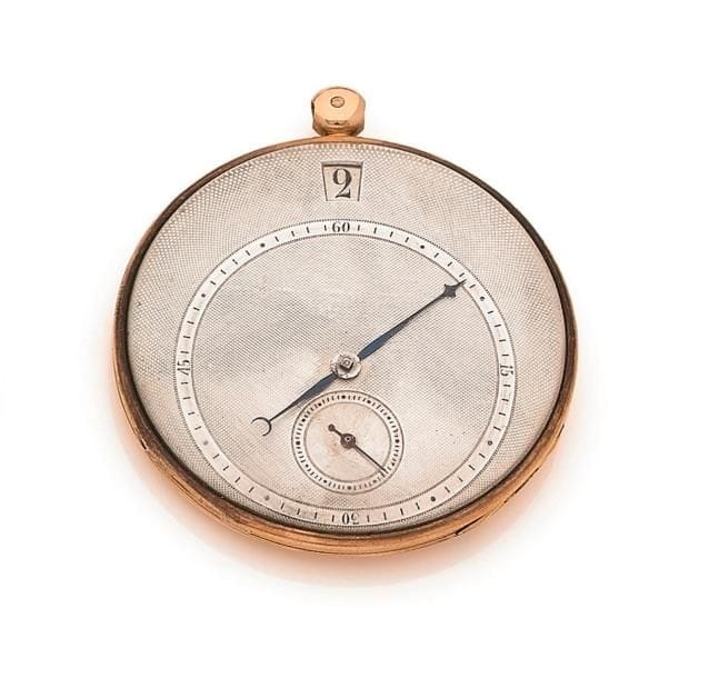 BLONDEAU N°725. Vers 1820. Montre de poche en or 18K (750‰), cadran en argent, disque pour indiquer les heures, trotteuse à 6H, mouvement à cylindre. Boîtier à décor rayonnant. Manque la bélière.
Diamètre : 48 mm
Poids brut : 65,6 g