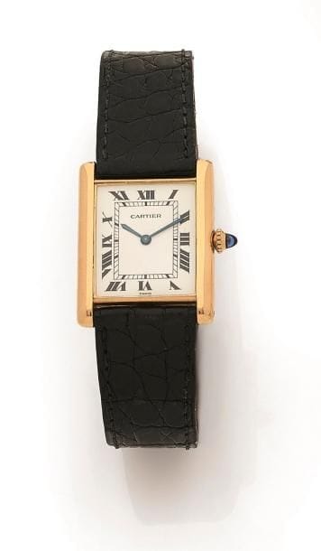CARTIER. Modèle Tank. N°960100000.
Montre bracelet d’homme en or jaune 18K (750‰) de forme rectangulaire, cadran blanc index peints chiffres romains formant les heures, mouvement à remontage mécanique, bracelet cuir avec sa boucle déployante signée en or jaune 18K . 
Cadran, boîtier, mouvement, signés. 
Hauteur : 30 mm
Largeur : 25 mm
Poids brut : 34,1 g