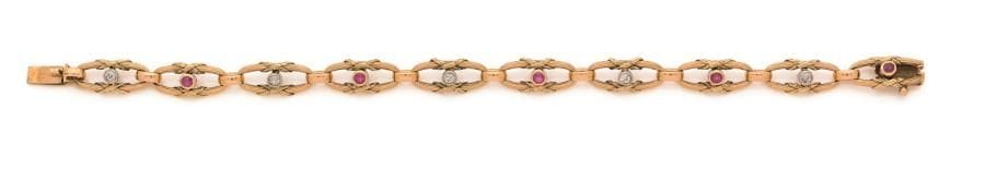 Bracelet en or 18K (750 ‰), articulé de maillons ovales, chacun noué d’un rubis ou d’un diamant rond. Travail du début du XXe siècle. Longueur : 18,7 cm environ. 
Poids brut : 17 g