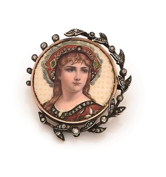 A.GOLAY & FILS. Broche ronde en or 18K (750 ‰), ornée d’un émail polychrome figurant une jeune fille en costume folklorique agrémenté de diamants taillés en roses, la monture soulignée d’une course de feuilles serties de diamants taillés en roses. Signée. Travail du début du XXe siècle. Diamètre : 3,3 cm environ. 
Poids brut : 15,5 g